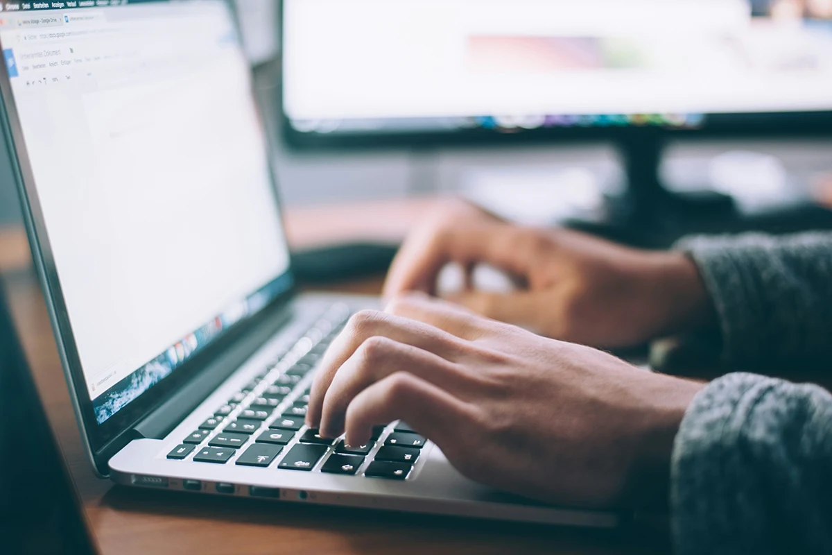 Image of hands typing on a laptop keyboard